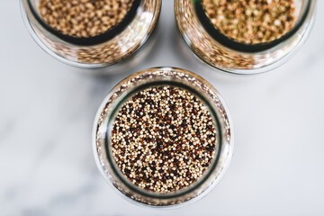 healthy whole grains and legumes in clear pantry jars on marble background including quinoa buckwheat and barley,, simple ingredients concept