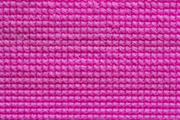 Pink yarn embroidered with a cross pattern on Plastic mesh canvas or vinyl weave to do invention for backgrounds and textures.