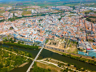Obraz premium Aerial panoramic view of modern Merida cityscape on banks of Guadiana River with ancient pedestrian Roman Bridge, Spain