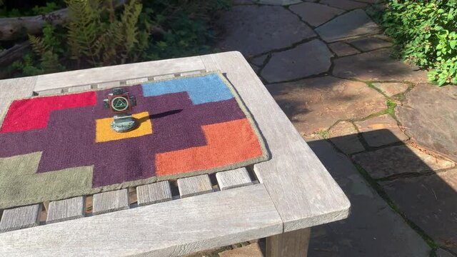 Peruvian Handmade Woven Textile Over Wooden Table With Chakana Cross At The Center. Slide Shot