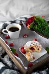 Powered jelly donuts with coffee in bed with flowers for breakfast