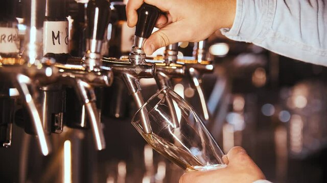 Pouring fresh draft beer from a barrel into a glass