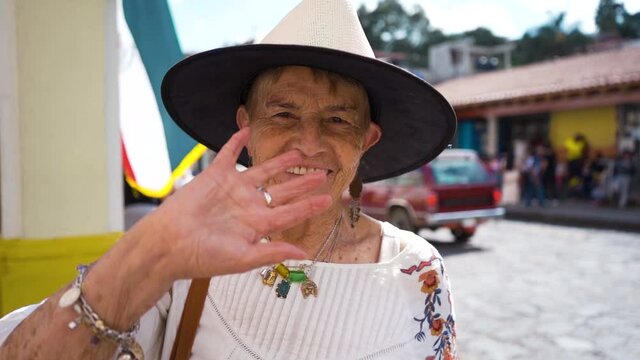 adult woman waving to the camera and smiling 