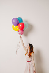 cheerful woman in a dress of colorful balloons