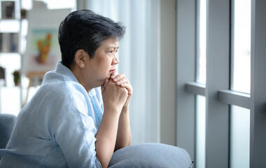 Depressed Asian female looking at window