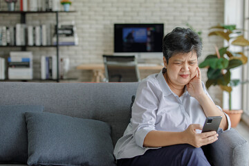 Obraz premium Frustrated Asian female using cellphone