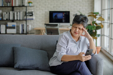 Obraz premium Frustrated Asian female using cellphone