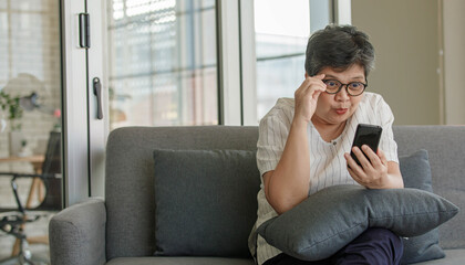 Astonished Asian woman using smartphone