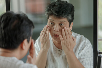 Fototapeta na wymiar Mature woman examining signs of aging