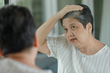 Obraz na płótnie Canvas Mature woman checking gray hair