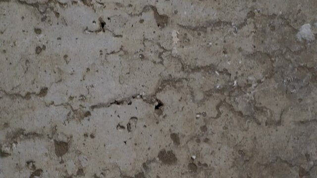 textured old gray concrete background stained with beige stucco with scratches and holes. free space. copy space. vertical move slider. close up. 4k
