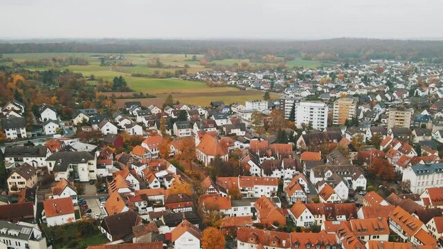 Aerial hyperlapse flying fast towards old church with red roof in small Europe town, Dietzenbach