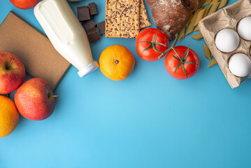 Vegetables, fruits, eggs, groceries on a blue background top view. Set of fresh products in an online shop with home delivery and a healthy variety of food. Copy space