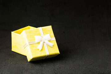 yellow gift box with open lid on black background with copyspace