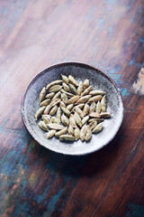 Green Cardamom Seeds on wooden background. Close up. Copy space.	