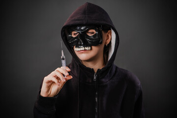 Drug addiction concept. Fear of vaccinations and injections. A person in a sweatshirt with a hood...
