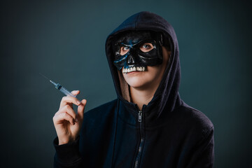 Drug addiction concept. Fear of vaccinations and injections. A person in a sweatshirt with a hood...