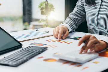 businesswoman or accountant working on calculator to calculate business data, and accountancy document. Business financial and accounting concept.