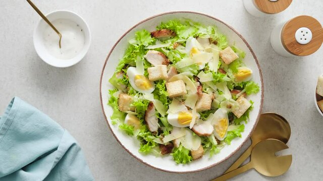 Caesar salad with grilled chicken breast, hard-boiled egg, croutons, parmesan cheese, green salad lettuce and dressing