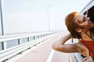 cheerful woman peeking out of the car window trip road travel