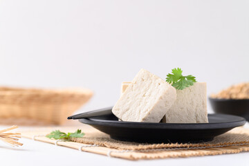 Sliced fresh tofu on black plate with white background, Vegan Food ingredients in Asian food
