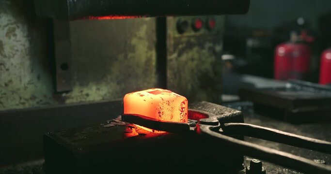 Very hot metal is placed with the help of forceps under the press and give it a smooth cubic form. Steel lights up when pressing
