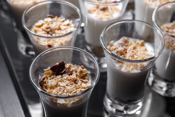 Creamy dessert of nuts in a glass stack on a dark background.