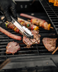 Closeup on grilling sausages and chicken skewers on a barbecue