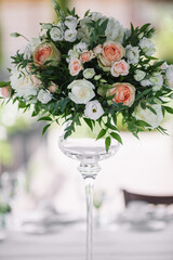 Wedding bouquet of delicate color on the table in glass vase close-up. White and pink roses.
