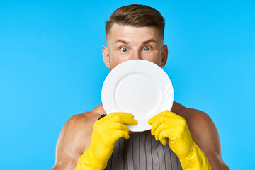 Dishwasher rubber gloves plate in hands blue background