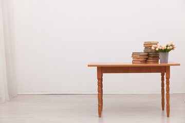 table with stacks of books for learning in a white room