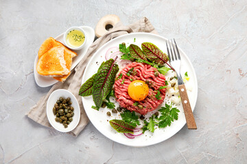 Beef steak tartare on light background. French cuisine concept.