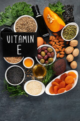 Foods high in vitamin E on dark background.