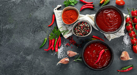 Spicy hot chilli tomato sauce on gray background.