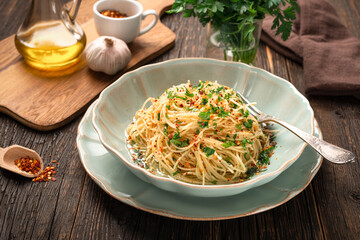 Close-up plate of freshly cooked spaghetti AGLIO E OLIO and ingredients