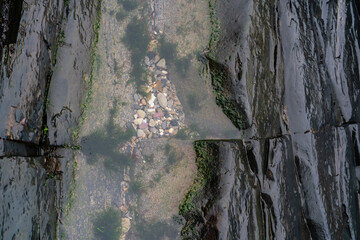 Wet rokcs  and water with small stones on low tide