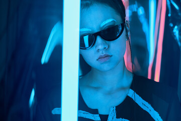 Teenage asian girl in sun glasses in neon light
