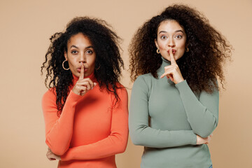 Two secret fun charming young curly black women friends 20s wearing casual shirts clothes say hush...