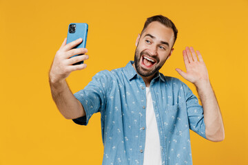Young smiling fun happy man 20s in blue shirt white t-shirt doing selfie shot on mobile cell phone...