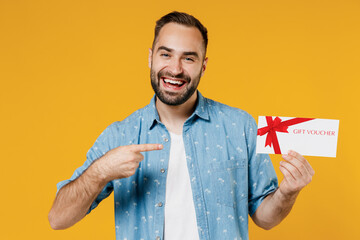 Young smiling happy caucasian man 20s wearing blue shirt white t-shirt hold point index finger on...
