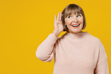 Elderly curious nosy woman 50s wearing pink casual knitted sweater look aside try to hear you...