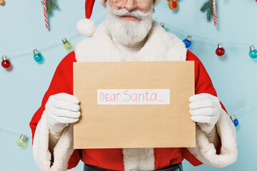 Cropped old Santa Claus man wears Christmas hat red suit hold letter with dear santa title text...