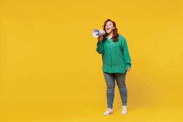 Full size body length bright young ginger chubby overweight woman 20s wears green shirt hold scream in megaphone announces discounts sale Hurry up isolated on plain yellow background studio portrait.