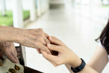 Obraz premium Young granddaughter taking care of grandmother with tender and care. 