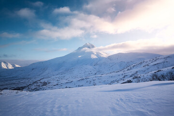 Fototapeta na wymiar Winter landscape. Vilyuchinsky volcano covered with snow against blue sky early in the morning. Kamchatka peninsula, Russia