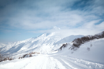 Fototapeta na wymiar Winter landscape. Vilyuchinsky volcano covered with snow against blue sky. Kamchatka peninsula, Russia
