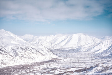 Winter landscape. Snow covered mountains covered with snow against blue sky. Kamchatka peninsula, Russia