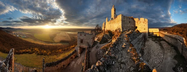 Papier Peint photo Lavable Marron profond Ruine du château Plavecky en Slovaquie - Panorama du coucher de soleil spectaculaire
