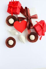 romantic composition for valentine's day. red heart, gift box and chocolates 