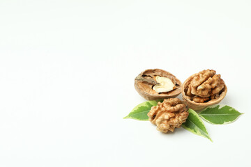 Walnuts with nutshell and leaves on white background